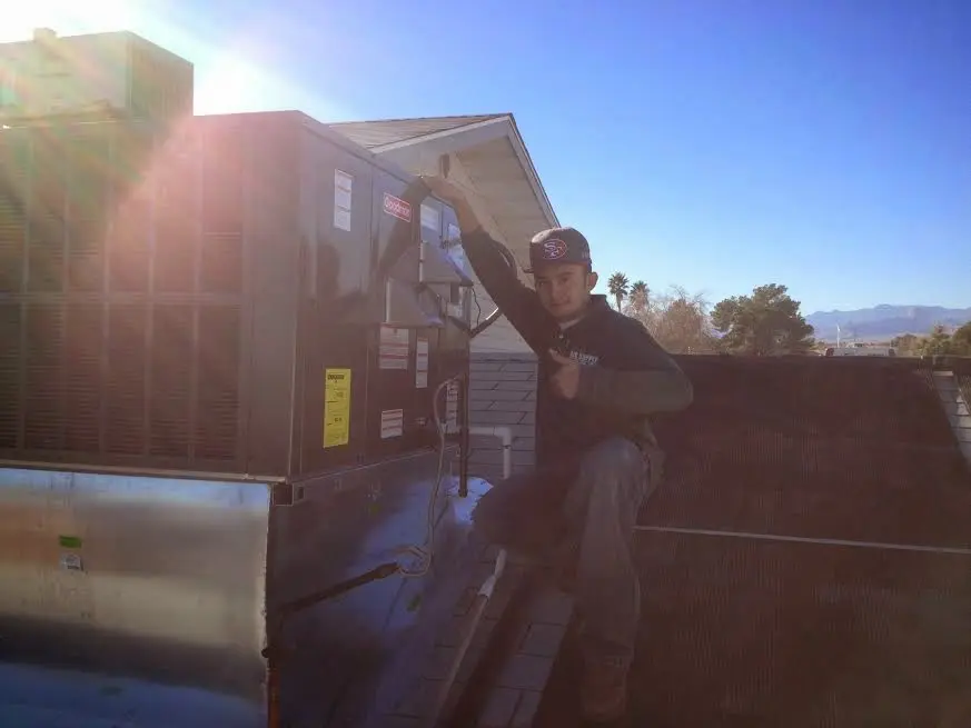 HVAC technician performing AC Tune-Up on a rooftop unit in San Martin